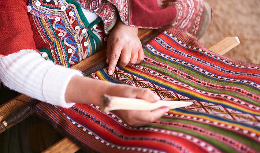 Peruvian artisan creating a textile out of alpaca 